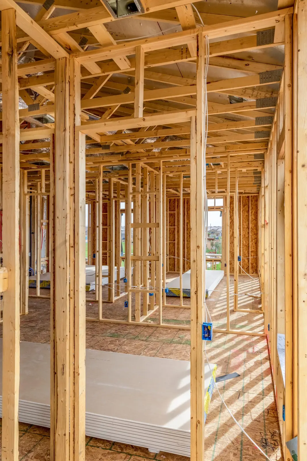Interior of a home at the framing stage, stud walls and door openings before drywall