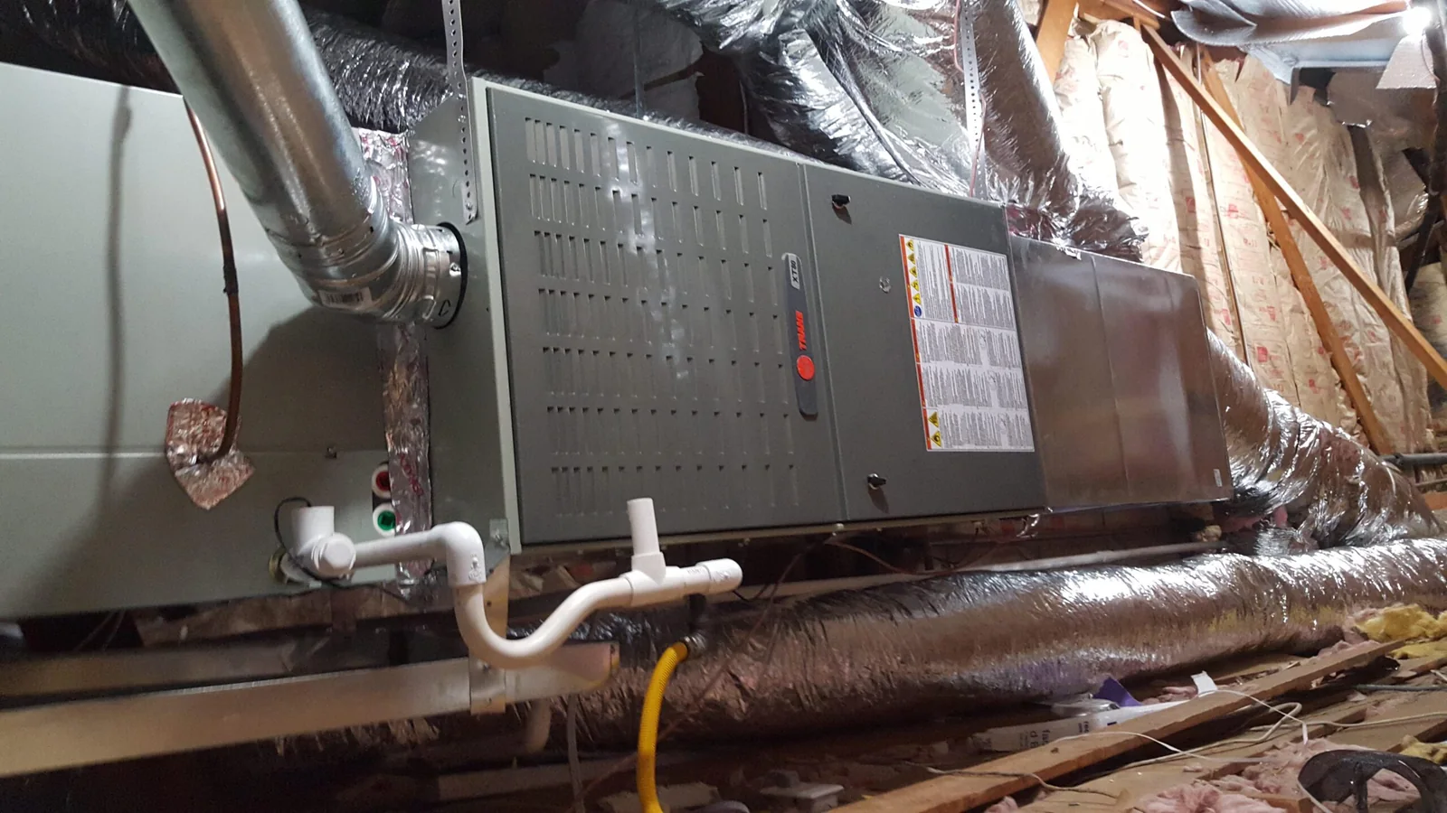 New Trane furnace and air handler installed in an attic with insulated ductwork